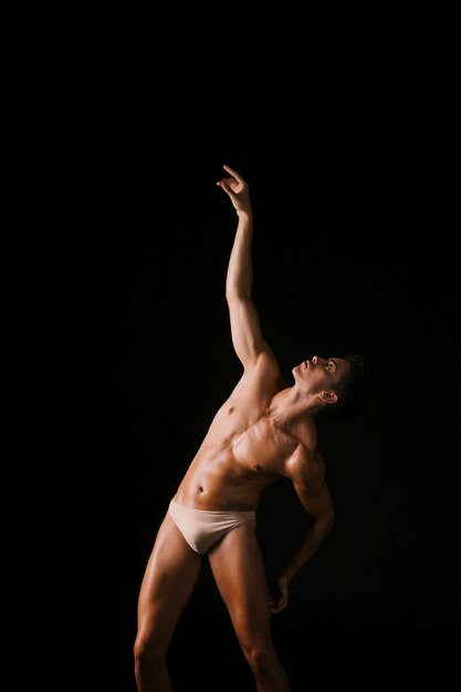 Jeune danseur regardant bras levé