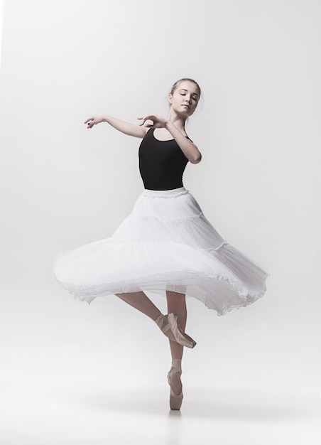 Jeune danseuse classique danse sur blanc