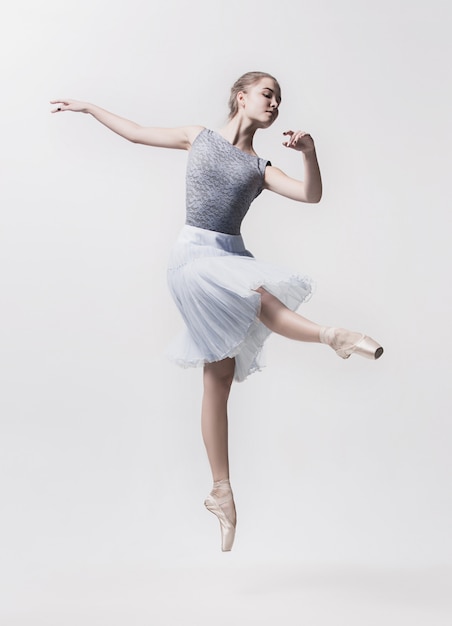 Jeune danseuse classique isolée sur blanc.