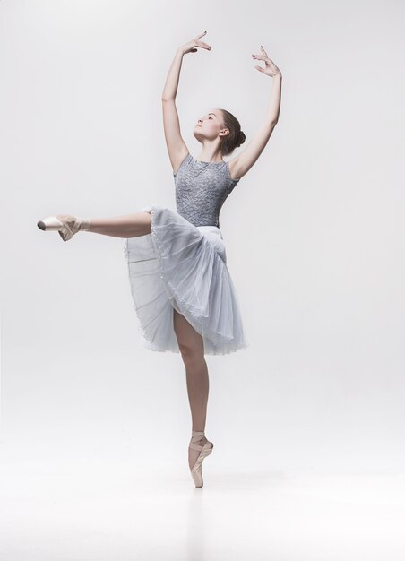 Jeune danseuse classique isolée sur blanc.