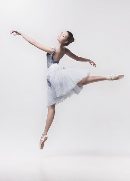 Jeune danseuse classique isolée sur blanc.