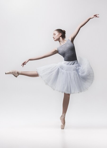 Jeune danseuse classique isolée sur blanc.