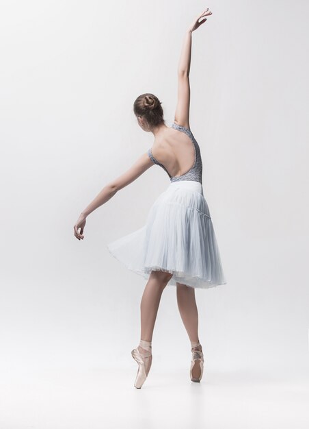 Jeune danseuse classique isolée sur blanc.