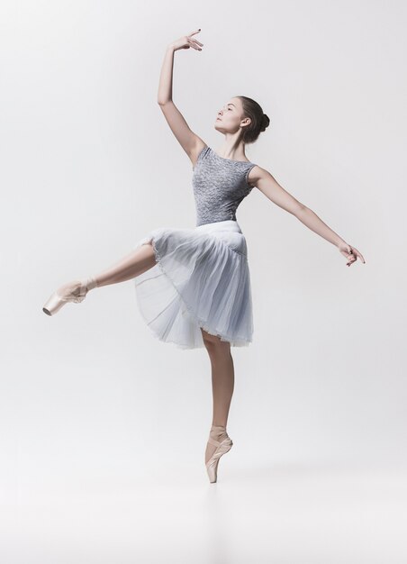 Jeune danseuse classique isolée sur blanc.