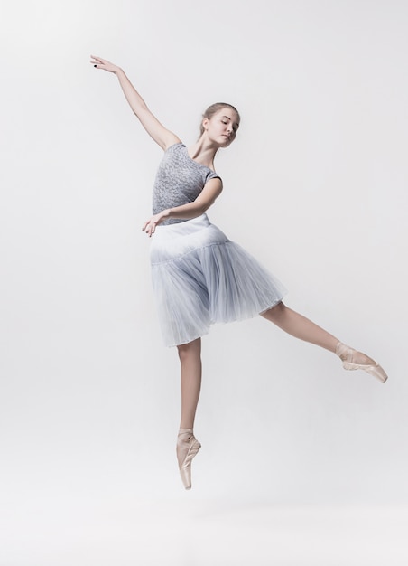 Jeune danseuse classique isolée sur blanc.