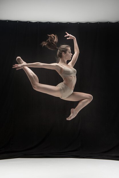 Jeune danseuse teen sur l'espace au sol blanc.