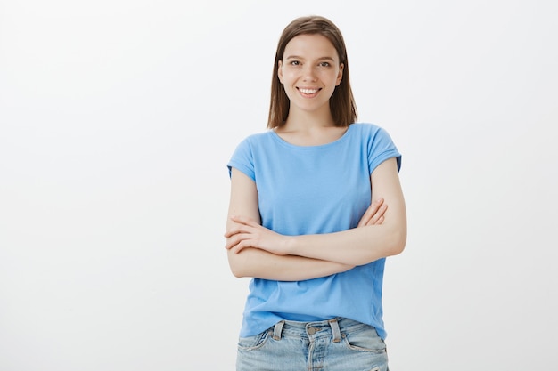 Jeune développeur féminin, debout comme un professionnel avec les mains croisées et souriant