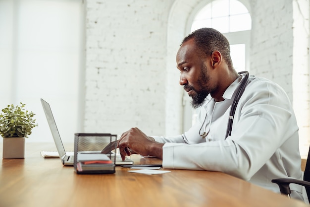 Jeune docteur pendant son travail, expliquant des recettes pour des drogues