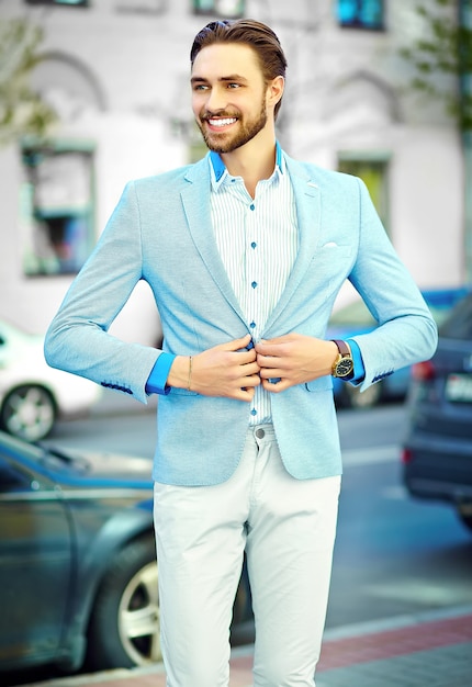 Photo gratuite jeune élégant confiant heureux beau souriant homme d'affaires modèle homme en costume bleu style de vie en tissu dans la rue