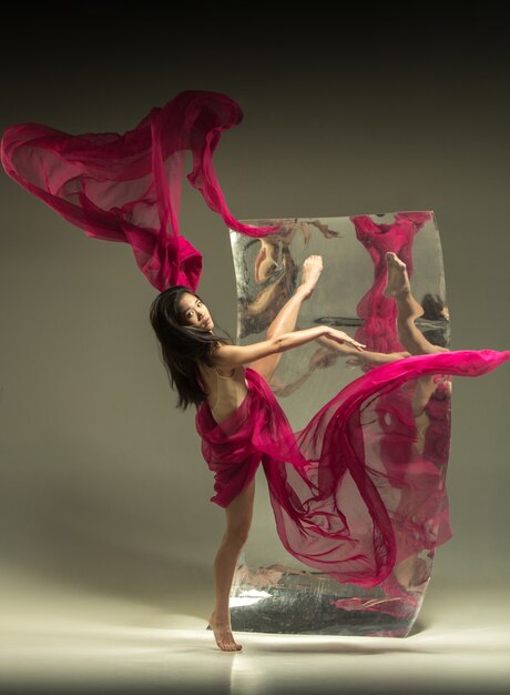 Jeune et élégant danseur de ballet moderne sur marron avec miroir