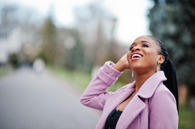 Jeune élégante belle femme afro-américaine dans la rue portant un manteau de tenue de mode