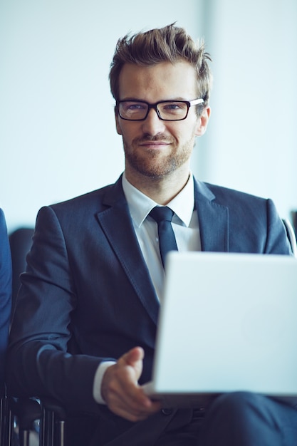 Photo gratuite jeune employé à lunettes en accordant une attention