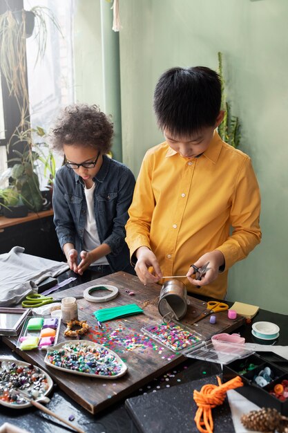 Jeune enfant faisant un projet de bricolage à partir de matériaux recyclés