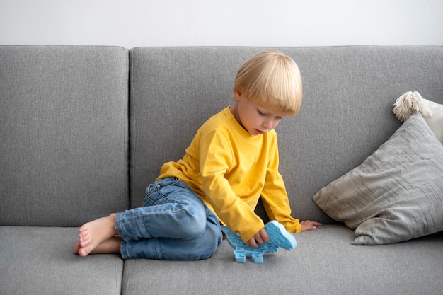 Photo gratuite jeune enfant jouant avec fidget à la maison