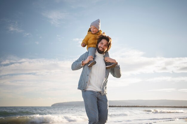 Jeune enfant avec parent au bord de la mer