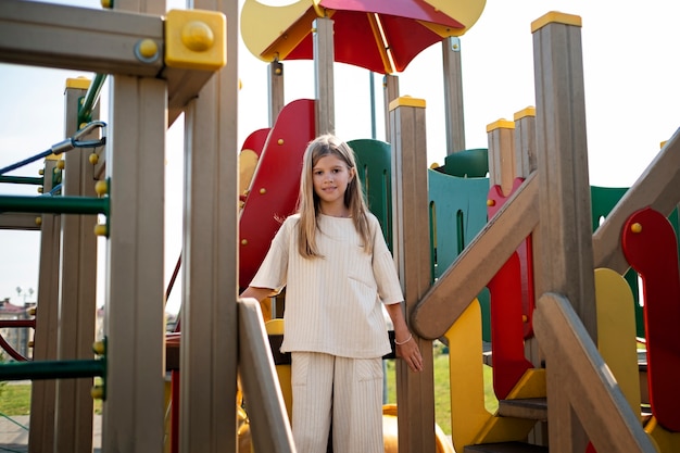 Photo gratuite jeune enfant s'amusant sur l'aire de jeux en plein air