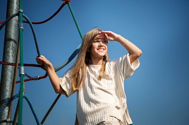 Jeune enfant s'amusant sur l'aire de jeux en plein air