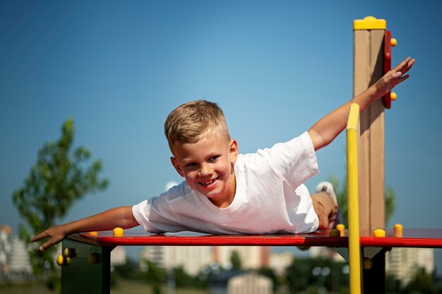 Jeune enfant s'amusant sur l'aire de jeux en plein air