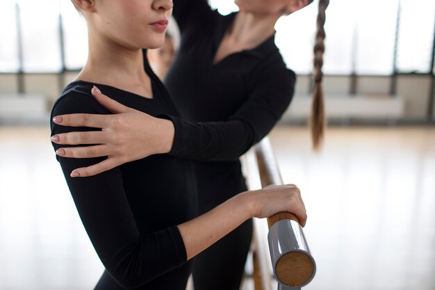 Jeune entraîneur aidant les stagiaires à pratiquer la gymnastique