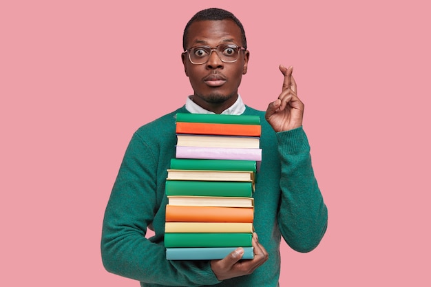 Photo gratuite jeune étudiant afro-américain tenant une pile de livres