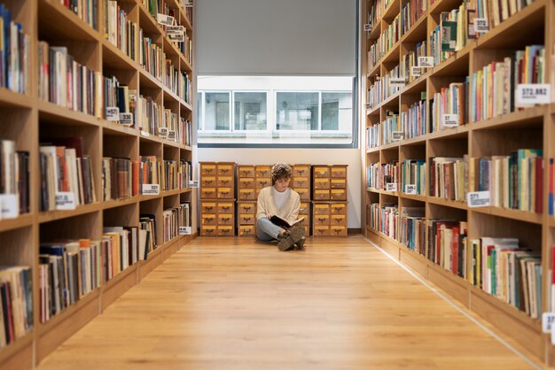 Jeune étudiant apprenant dans la bibliothèque