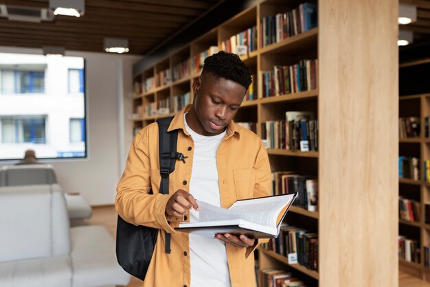 Jeune étudiant apprenant dans la bibliothèque