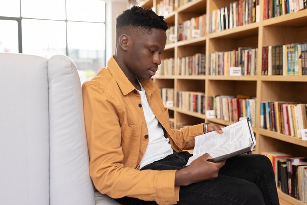 Jeune étudiant apprenant dans la bibliothèque