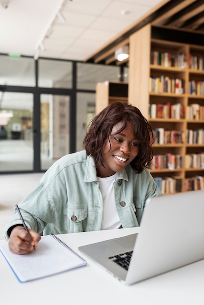 Photo gratuite jeune étudiant apprenant dans la bibliothèque