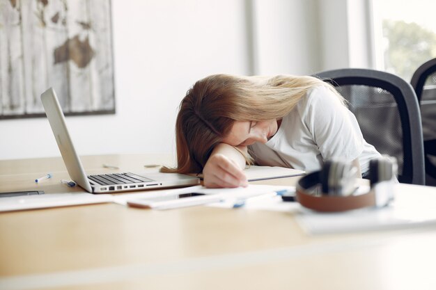 Jeune étudiant assis à la table et dormant