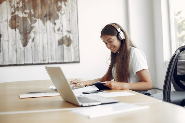 Jeune étudiant assis à la table et utilise son ordinateur portable