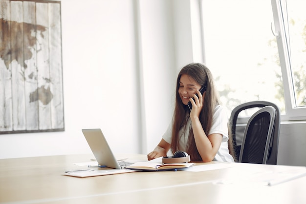 Jeune étudiant assis à la table et utilise son ordinateur portable