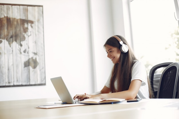 Jeune étudiant assis à la table et utilise son ordinateur portable