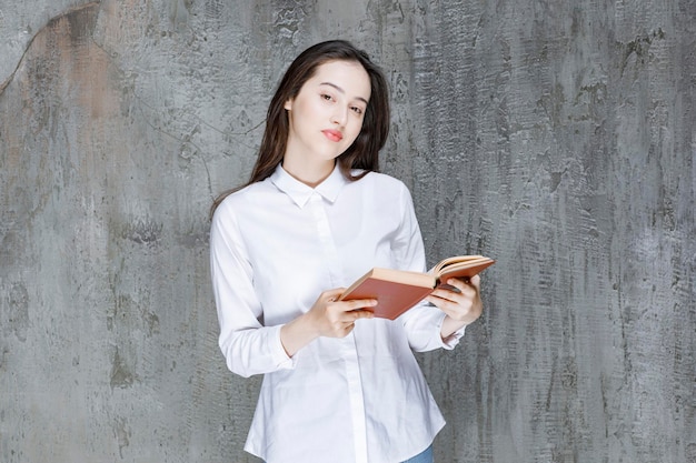 Jeune étudiant ou enseignant avec un livre ouvert debout et posant. Photo de haute qualité