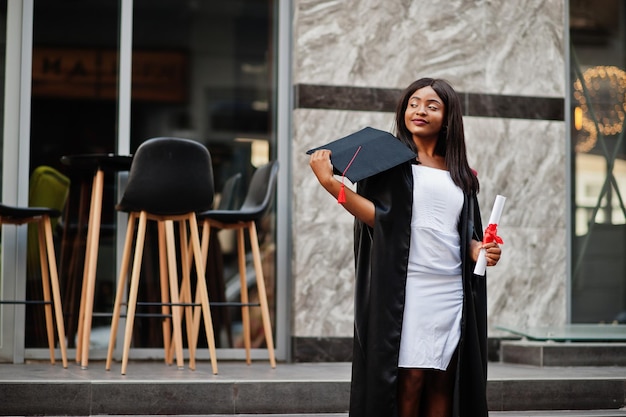 Jeune étudiante afro-américaine avec diplôme pose à l'extérieurxA