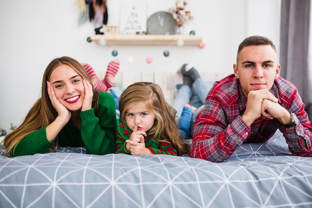 Jeune famille allongée sur le lit