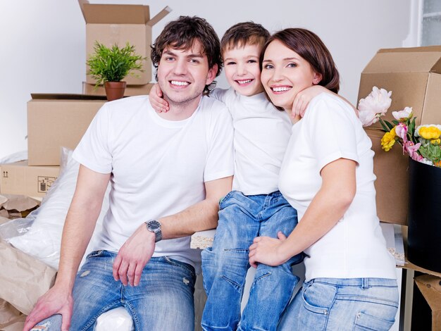 Jeune famille amicale heureuse assis ensemble dans leur nouvel appartement