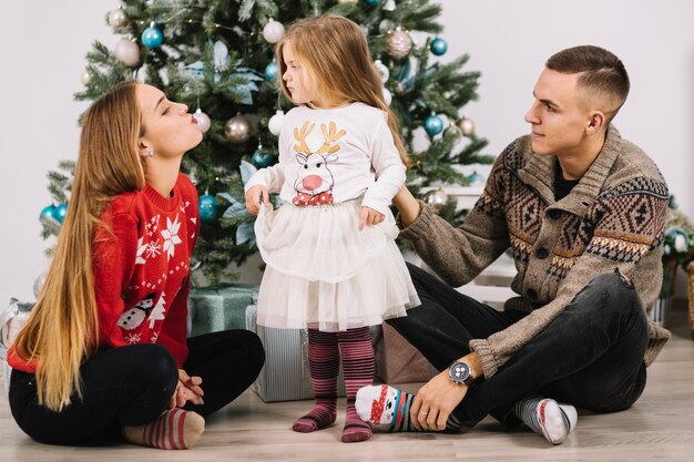 Jeune famille célébrant Noël à la maison
