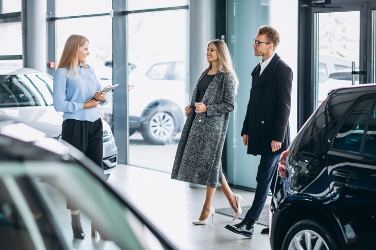 Photo gratuit jeune famille choisissant une voiture dans une salle d'exposition
