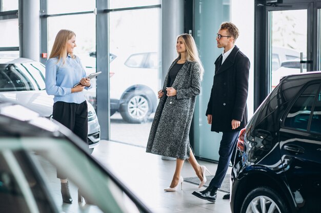 Jeune famille choisissant une voiture dans une salle d'exposition