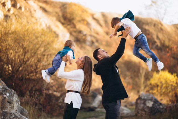 Jeune famille avec deux fils ensemble à l'extérieur du parc