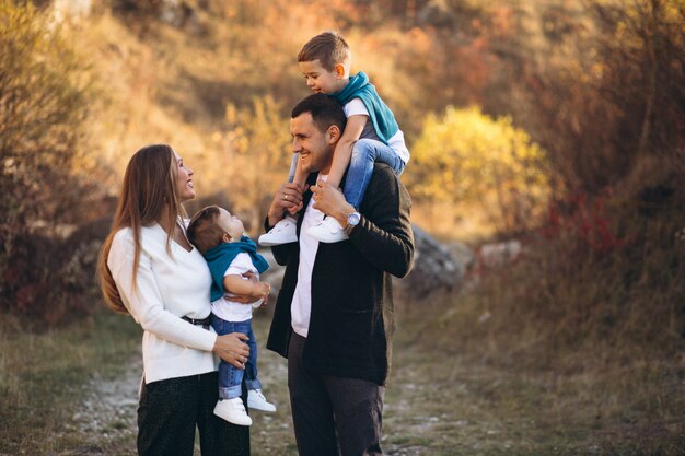 Jeune famille avec deux fils ensemble à l'extérieur du parc