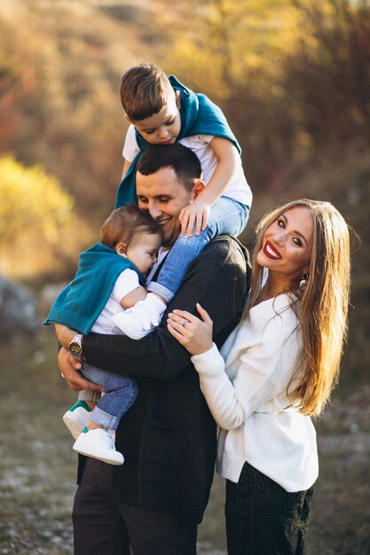 Jeune famille avec deux fils ensemble à l'extérieur du parc