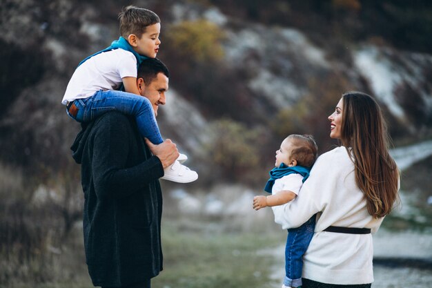 Jeune famille avec deux fils ensemble à l'extérieur du parc