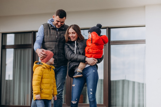 Jeune famille avec deux petits frères près de la maison