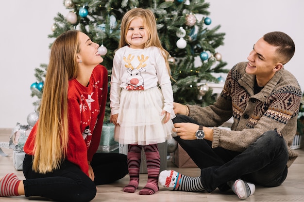 Jeune famille en face de l&#39;arbre de Noël