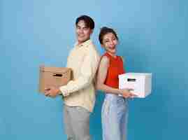 Photo gratuite une jeune famille heureuse, un couple asiatique, un homme et une femme, déménagent des boîtes dans leur nouvel appartement.