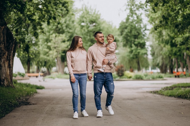 Une jeune famille avec leur petit bébé dans le parc