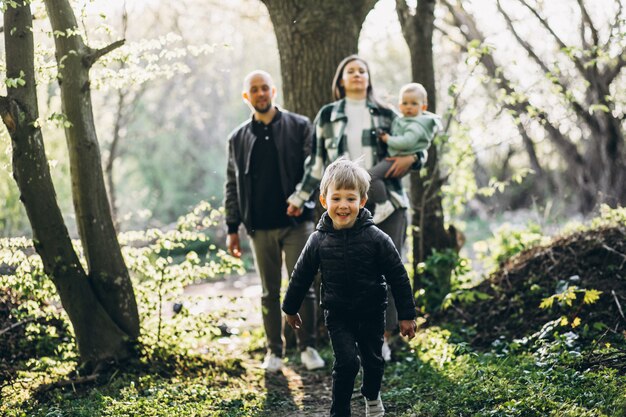 Jeune famille avec leurs enfants s'amusant dans la forêt