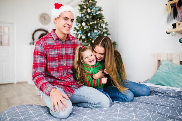 Jeune famille sur le lit à Noël