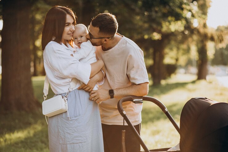 Photo gratuit jeune famille marchant avec bébé dans le parc